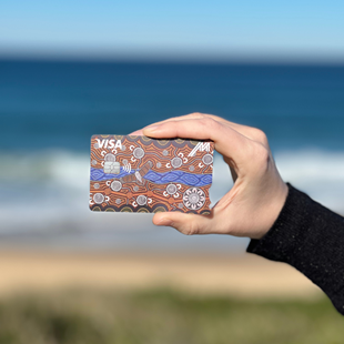 Hand holding Indigenous artwork bank card.